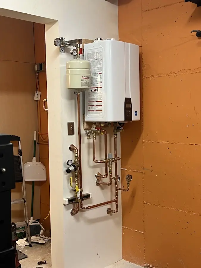 Plumbing technician inspecting water heater connections in Gardnerville Ranchos